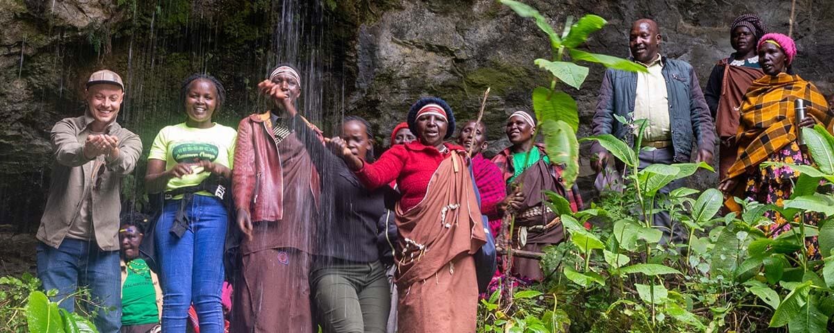 An expression of joy upon visiting a sacred cave along the slopes of Mount Elgon.