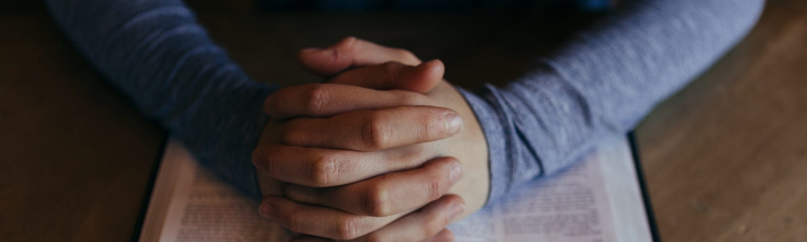 Hands folded on Bible