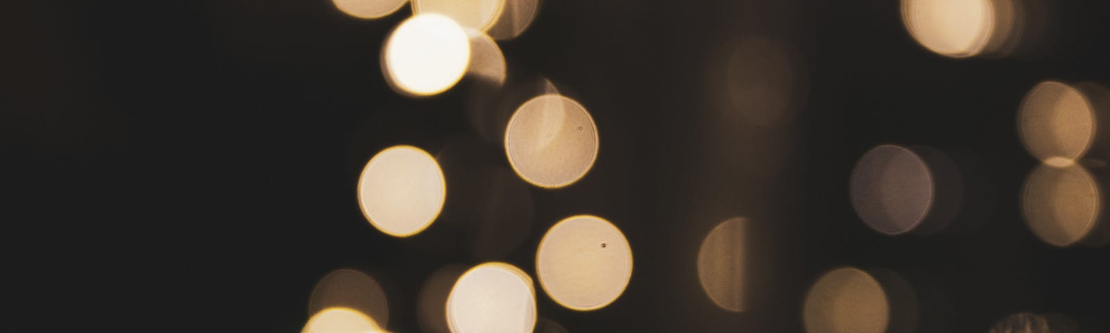 Image with a brownish black background and white bokeh rounds to make it looks like spots someone sees when they faint.