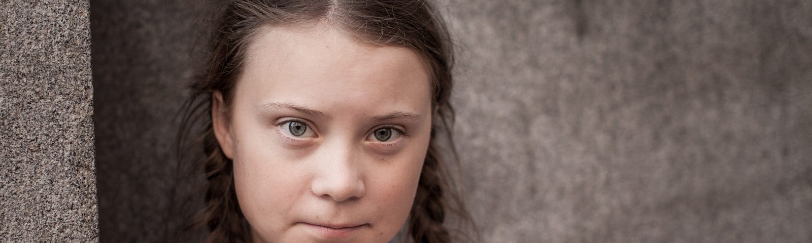 An image of Greta Thunberg looking straight into the camera with a serious expression.