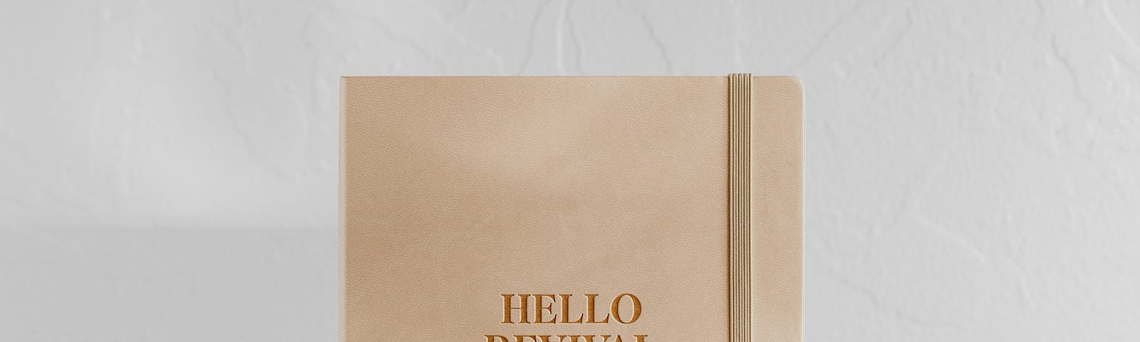 A journal with a beige cover and the words hello revival on the front.