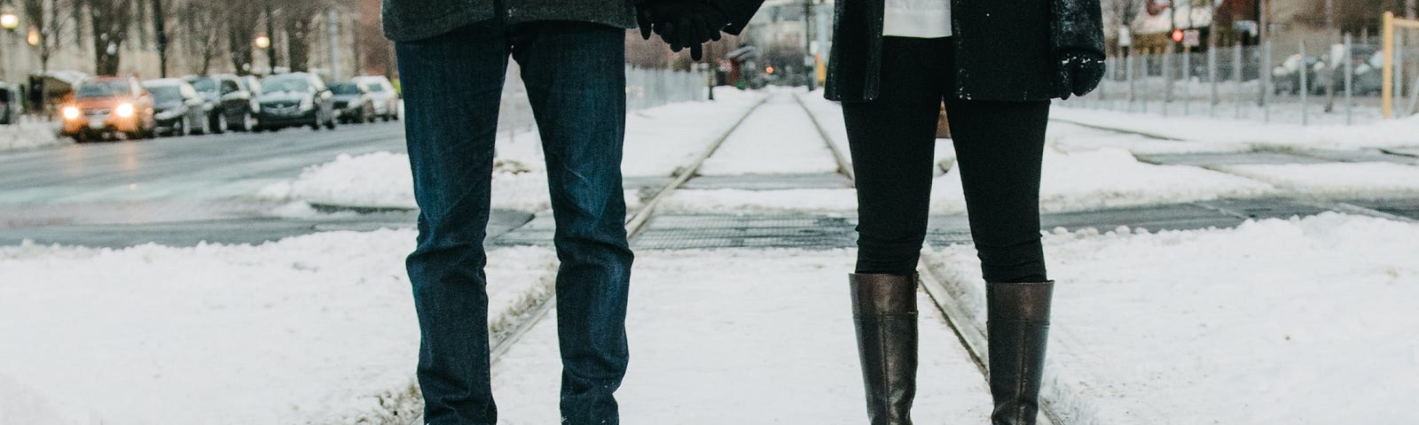 Lovers holding hands on a snowy covered street