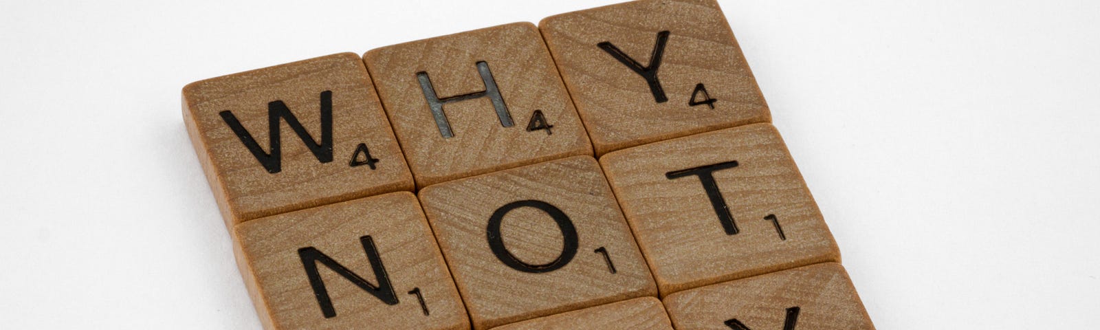 Scrabble tiles spelling “Why Not Try”