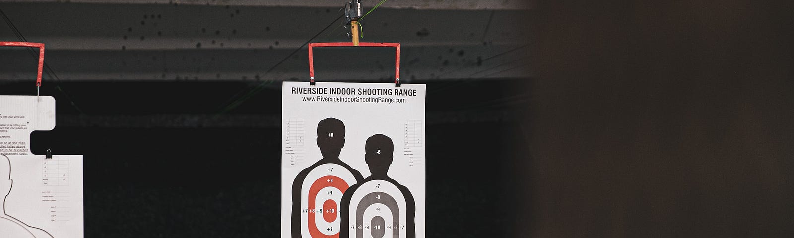 A picture of a shooting range target, covered in bullet holes.