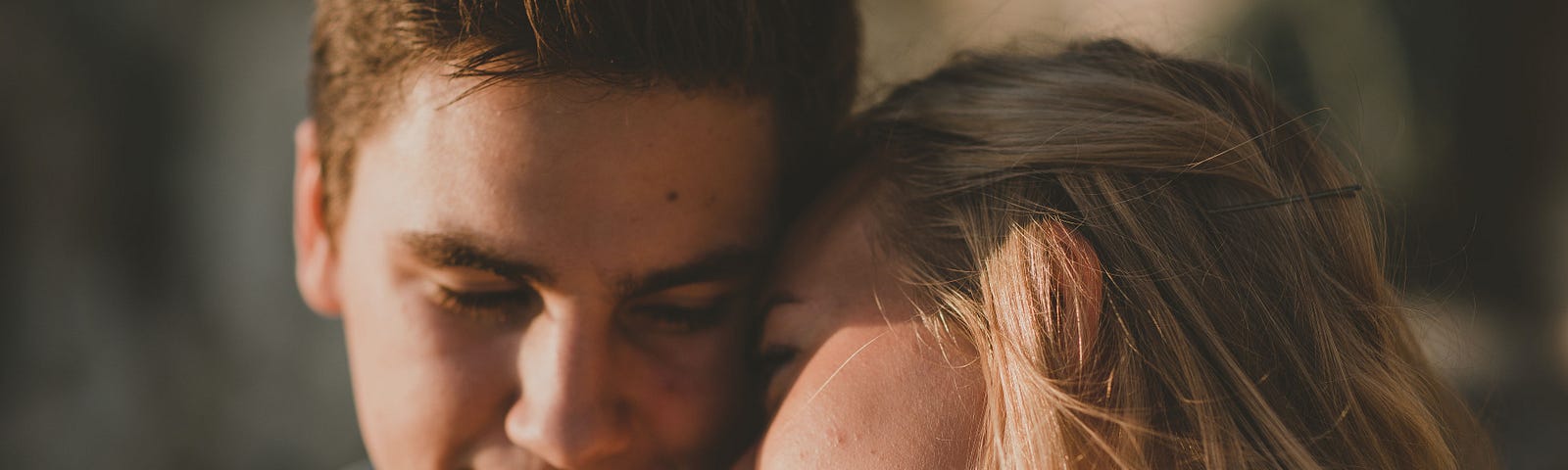 Photo of a young couple. She’s resting her head on his shoulder.