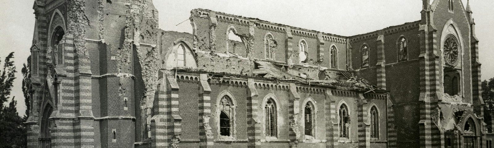 World War I soldiers gathered around the ruins of a heavily damaged church, highlighting the impacts of war on historical architecture.