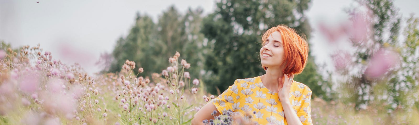 A girl standing in amidst wildflowers. She exudes happiness.