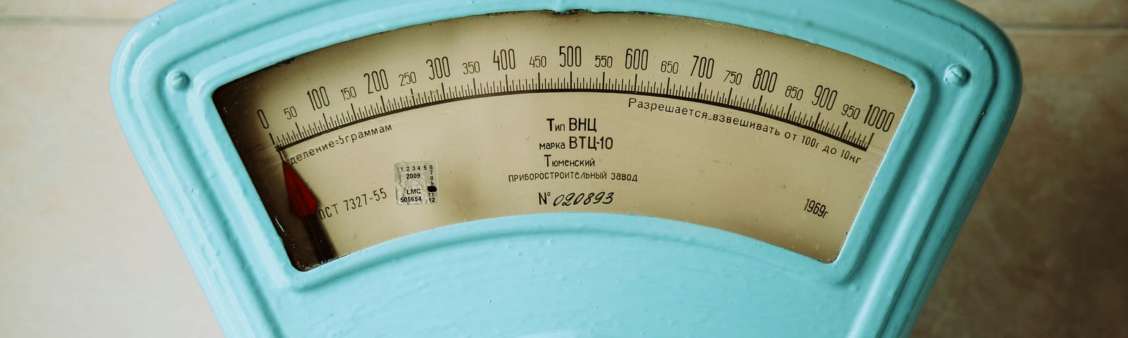 A close-up of a vintage blue analog weight scale.