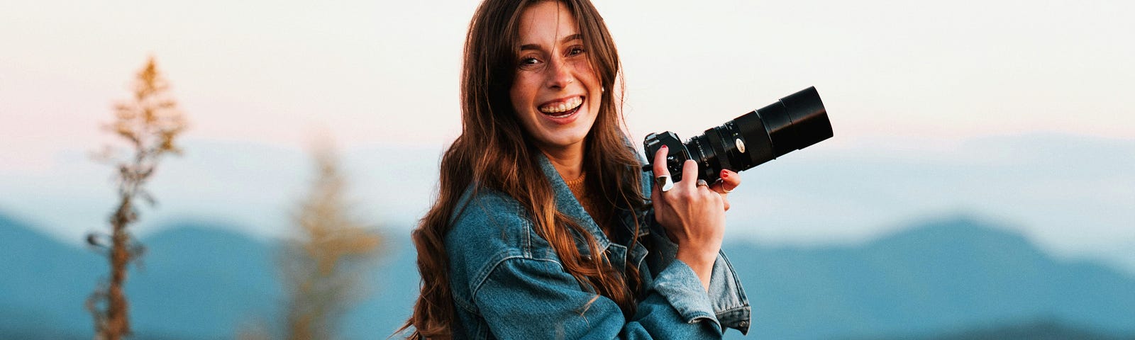 Photo by Jake Johnson on Unsplash of a woman holding a camera