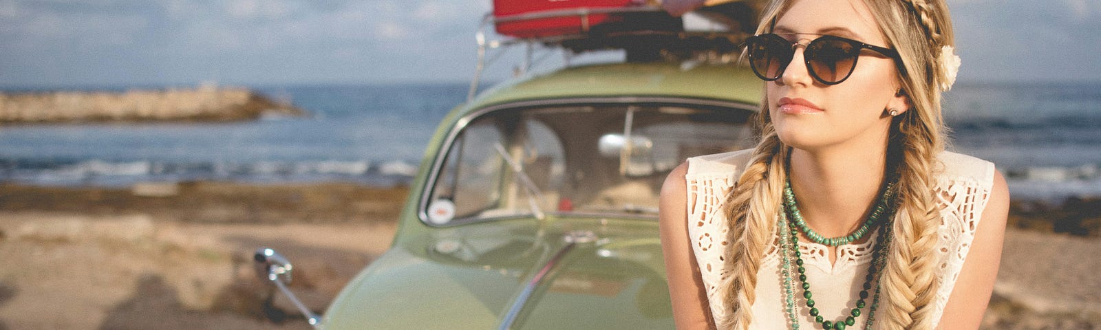 Lady on a trip, likely going through a carefree stage in her life. Sitting on a Volkswagen with an interesting product on itls roof rack.