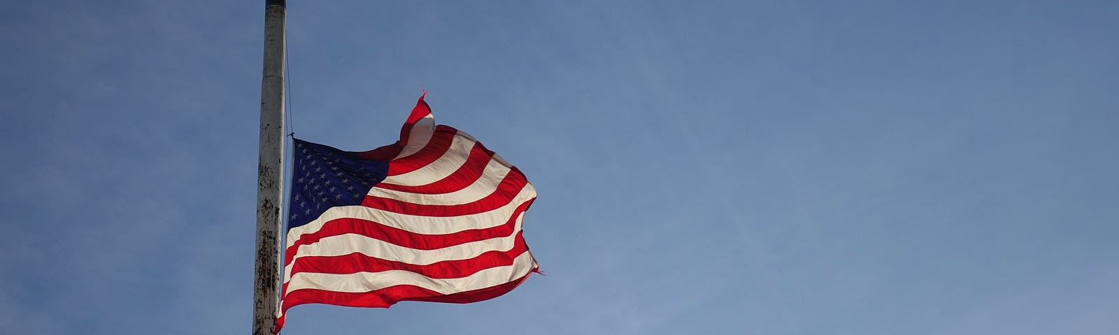 An American flag raised at half mast.