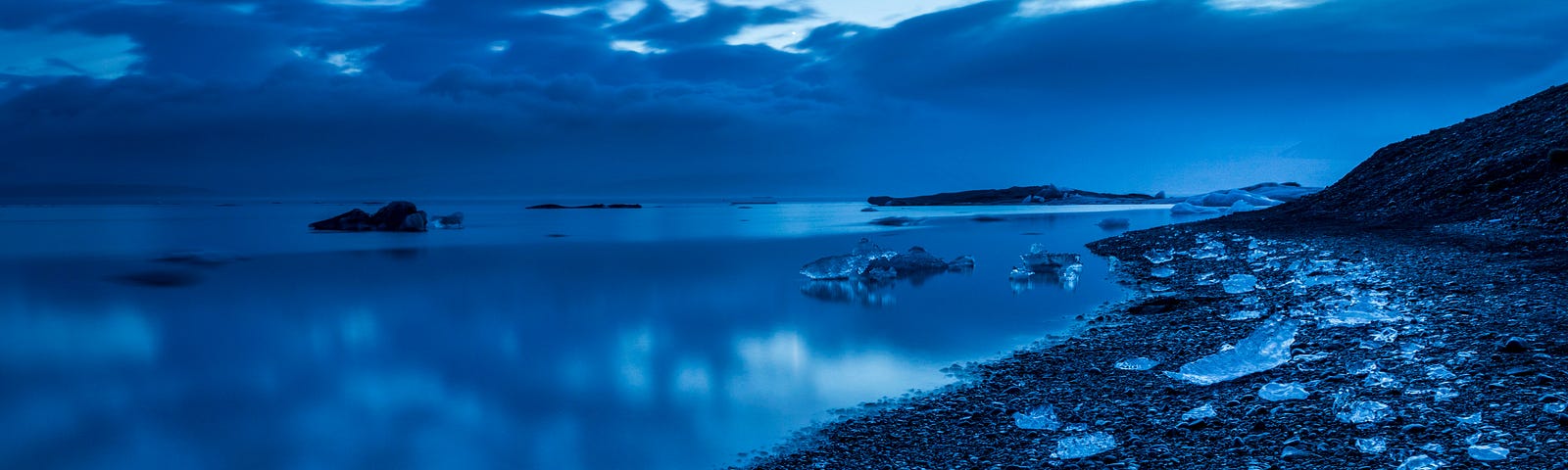 An icy beach, very blue image in low light