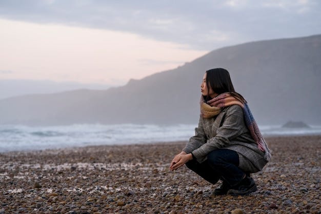 Young woman contemplating sunset at lake shore