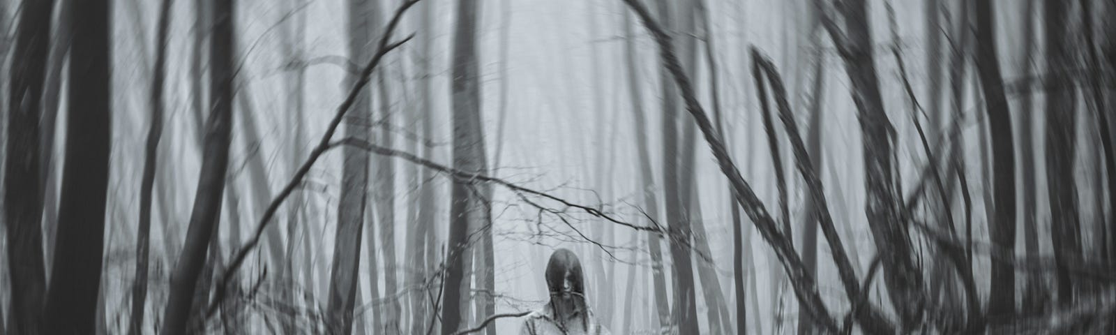 A girl with open hair standing surrounded by broken tree trunks