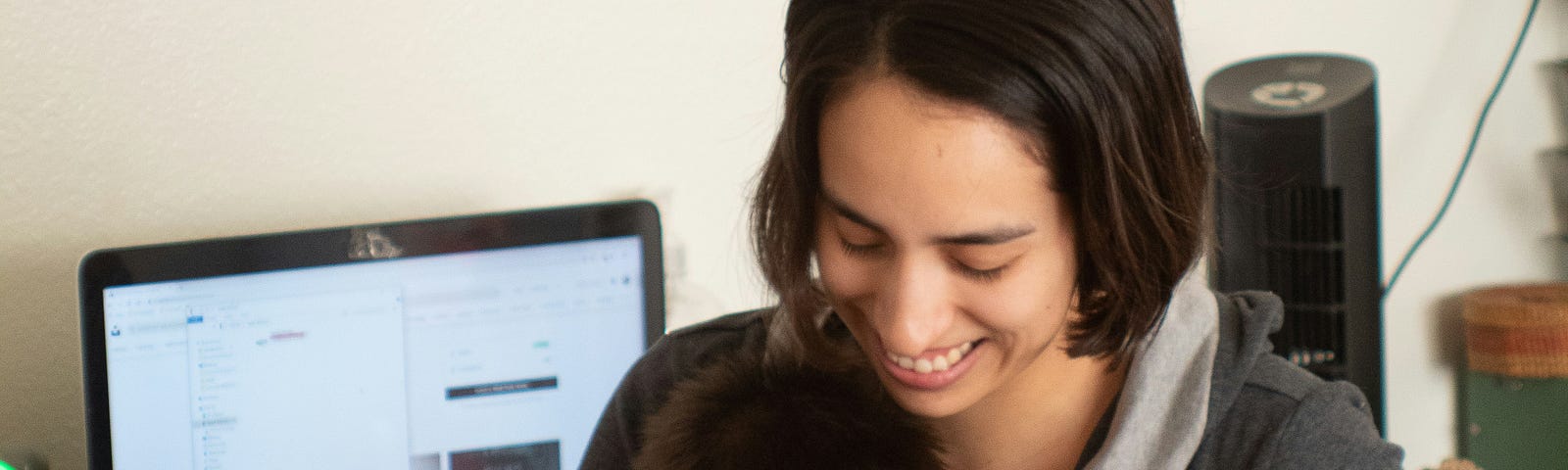 A woman working with her baby in her lap. Photo by Brian Wangenheim on Unsplash