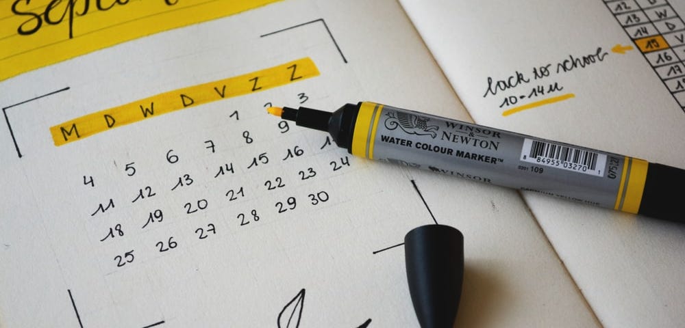 a yellow highlighter lying on an open bullet-journal monthly spread.
