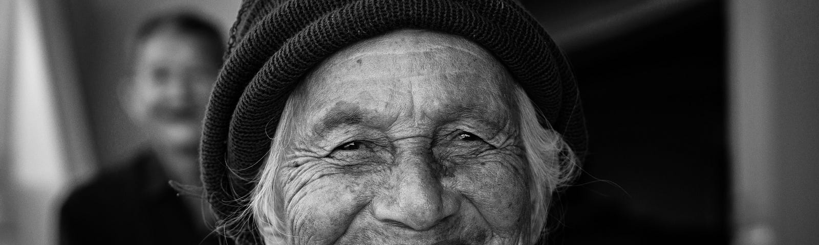 smiling old woman in a knit cap, photo in black and white