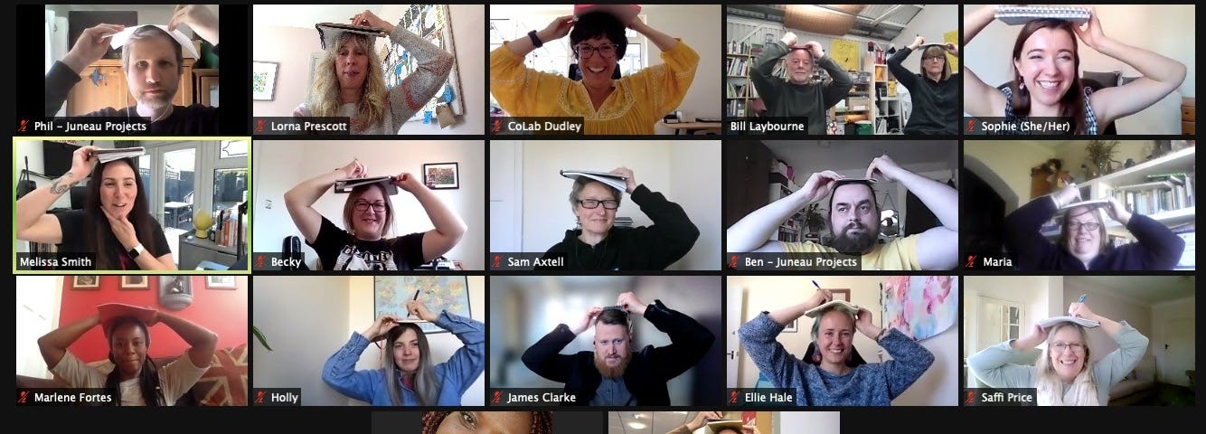 Screenshot of 17 screens from the zoom where each session participant has their paper on their head to draw their face