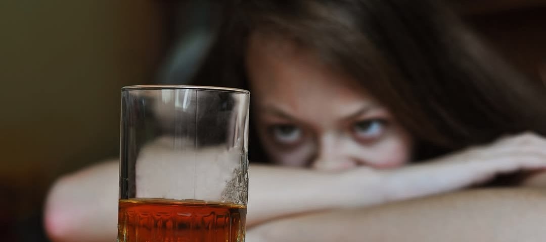 Woman looking at an alcoholic drink.