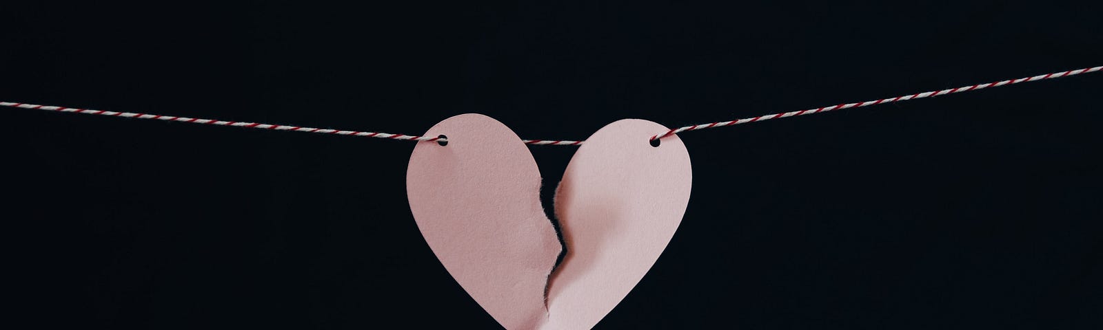 A broken heart hanging on a string.