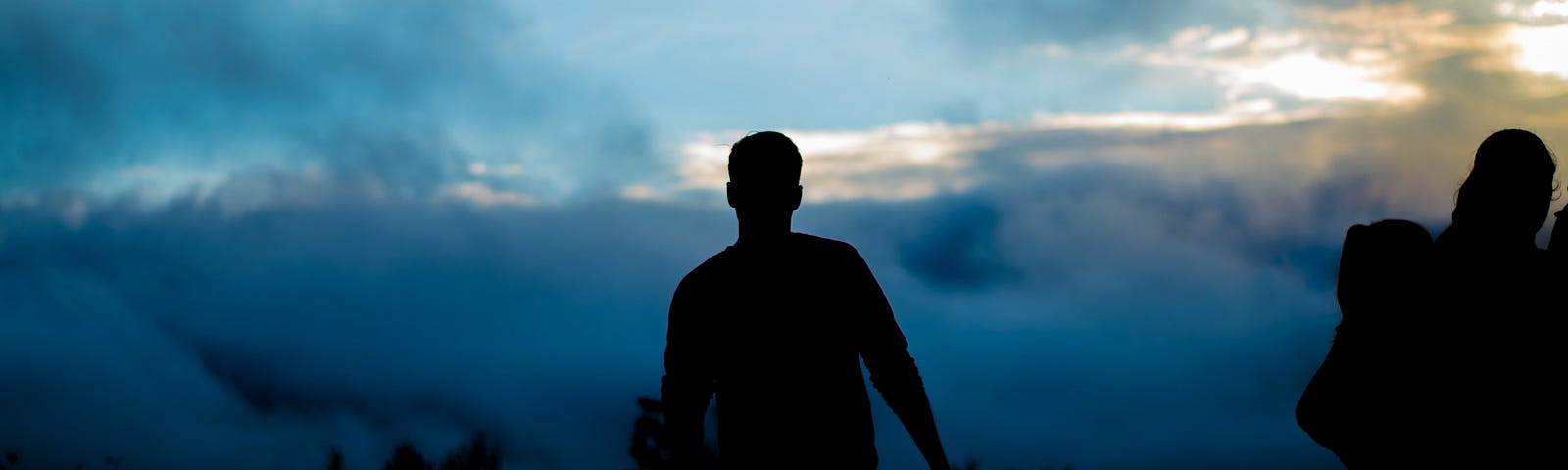 dark silhouette of guy against blue black sky
