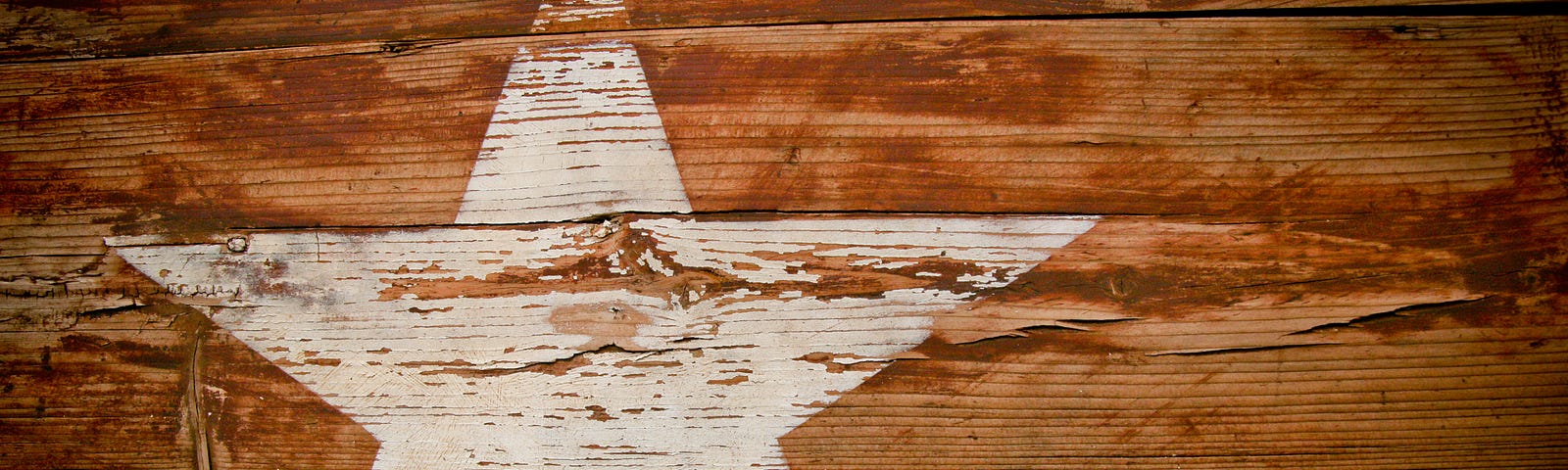 One faded white star on a piece of weathered wood