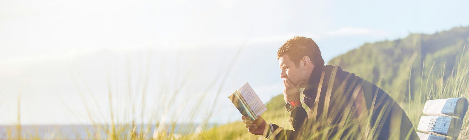 Reading an open book by the sea. Love of reading and writing.