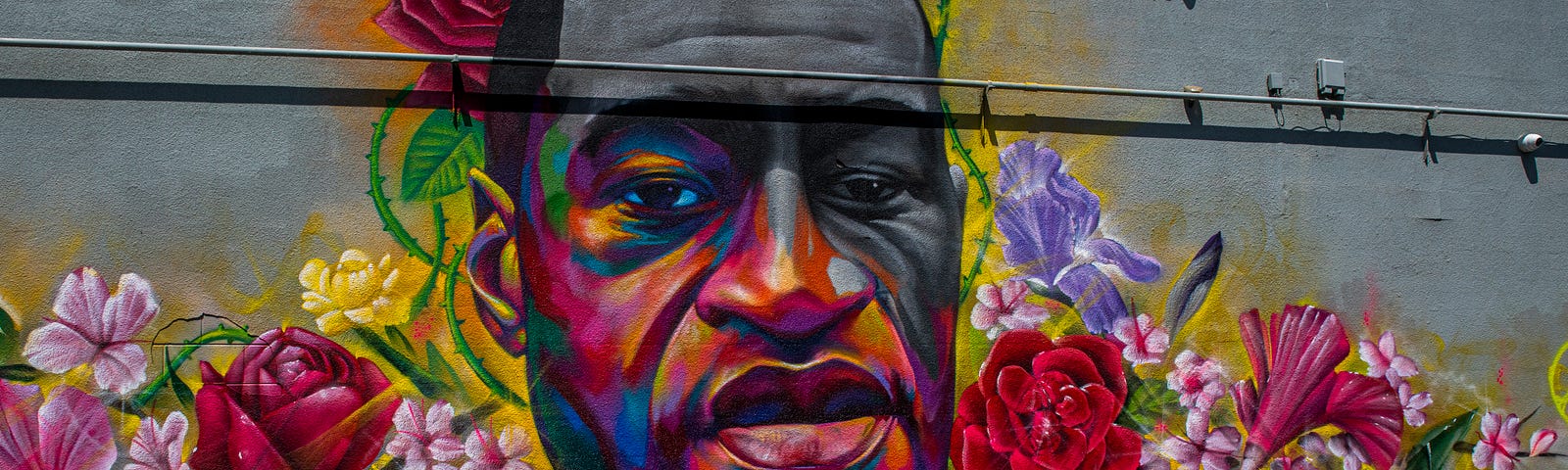 A colorful mural of George Floyd with the signs, “I’m sorry I failed you,” “Black Lives Matter,” and “Spread Love,” stand up. Black Lives Still Matter even after the Black Lives Matter protests occurred in 2020 with the hashtag, #BlackLivesMatter.