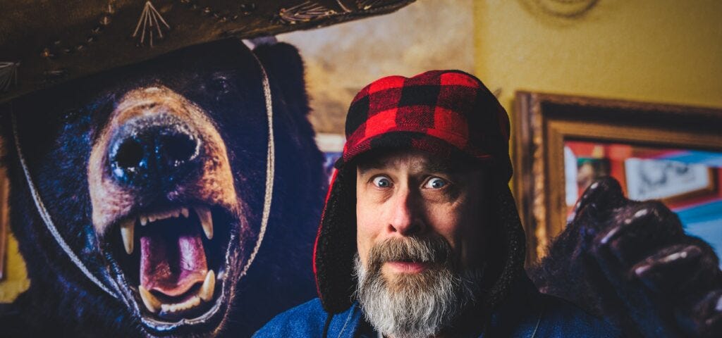 Frightened man in a hunting cap with an angry stuffed bear over his shoulder. Image courtesy of Brett Sayles at Pexels