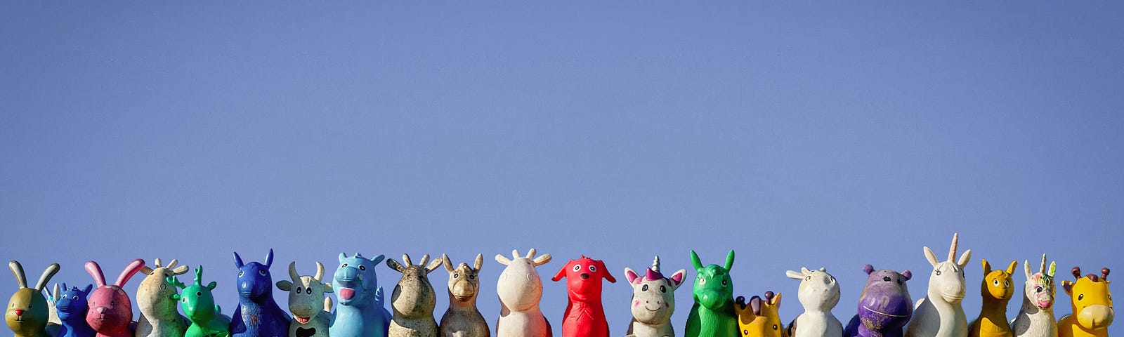 A line-up of toy animals sitting on top of a green container