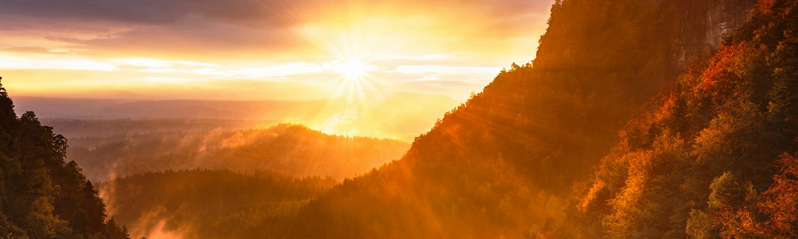 View of the sun setting over the Himalayan Mountains and creating a red glow.