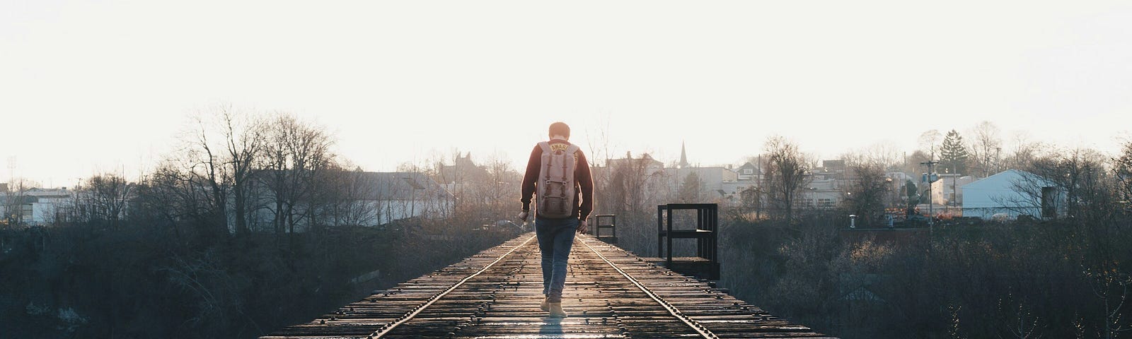 Man walking alone down railroad tracks