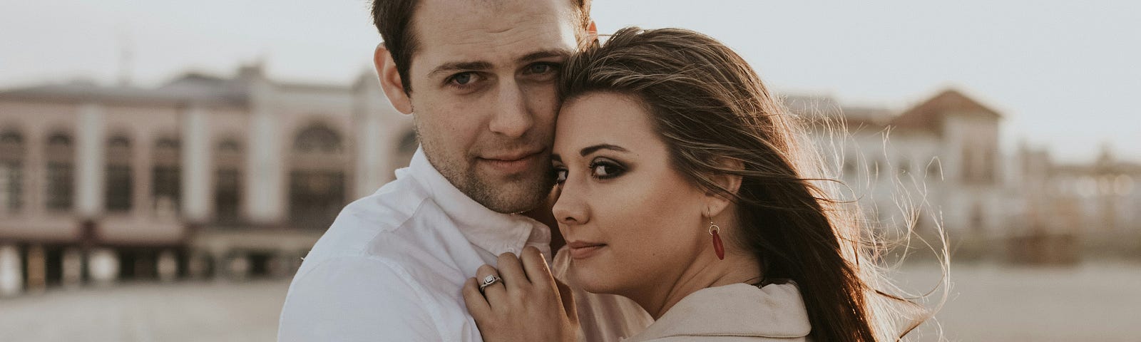 A man and a woman holding each other while looking at the screen.