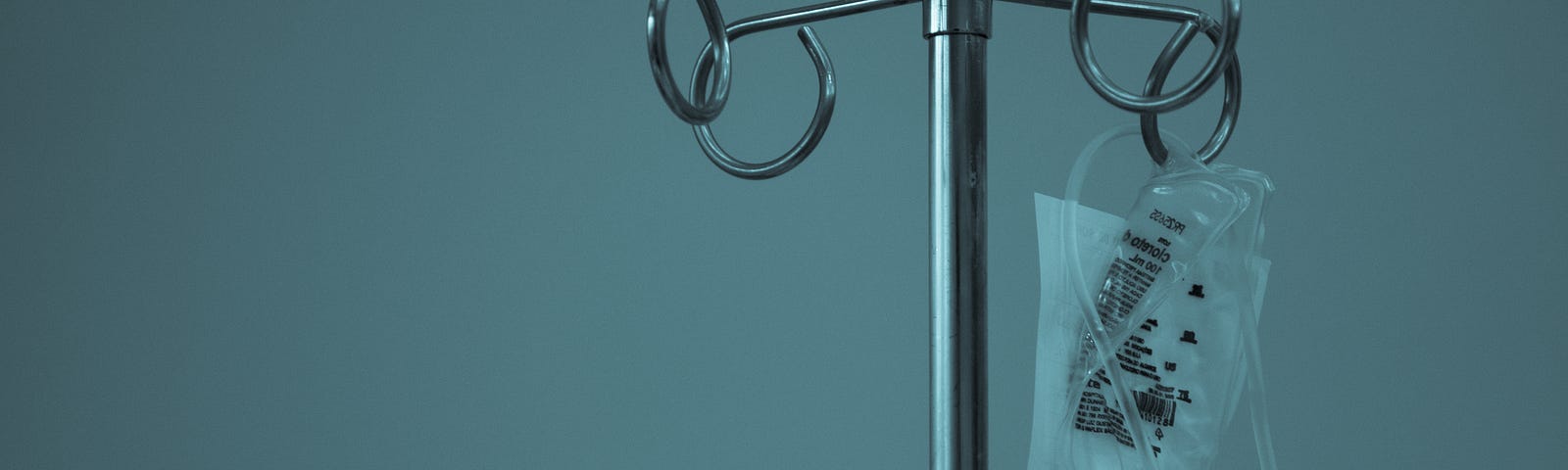 An iv pole with an iv bag, and blue mood lighting.