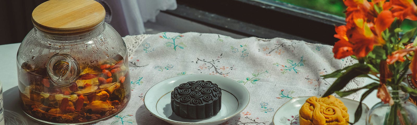 Different mooncake types on the table with the tea in the jar