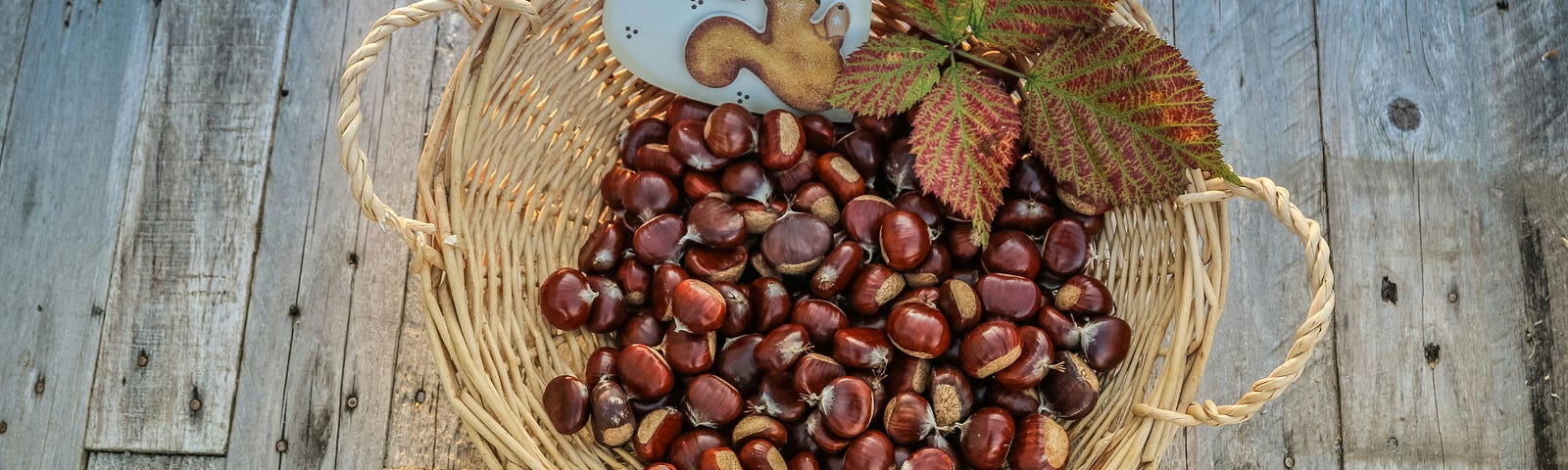 A basket of chestnuts with leaves and a ceramic heart