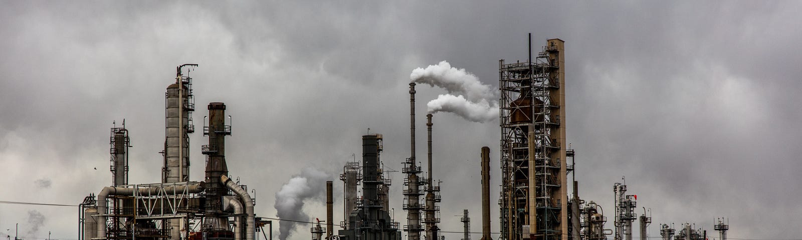 A picture of a factory with smoke coming out of its smoke stacks