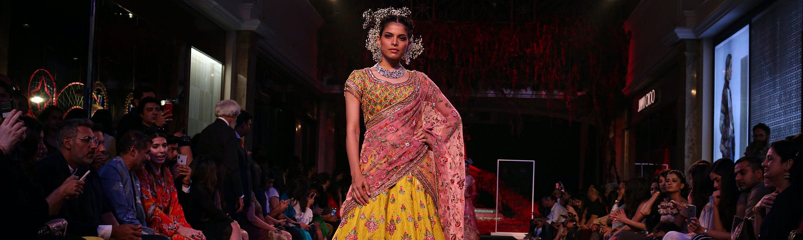 A woman in a beautiful yellow and pink dress on a stage