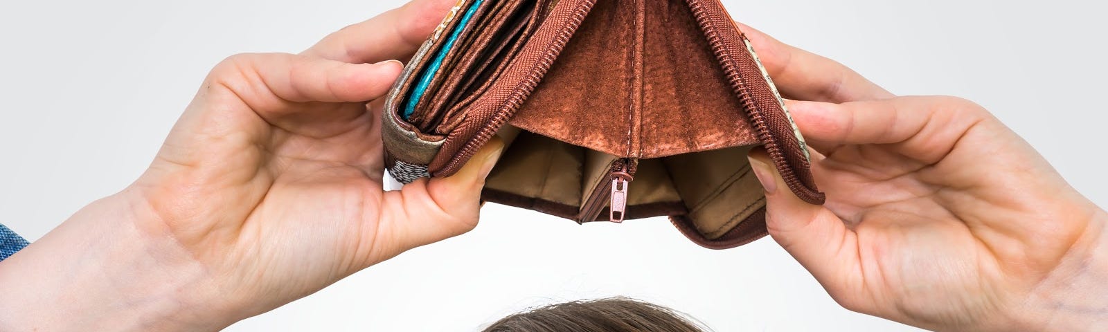 Woman holding empty wallet over her head