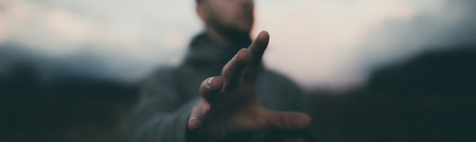 A man with his hand outreached toward the camera