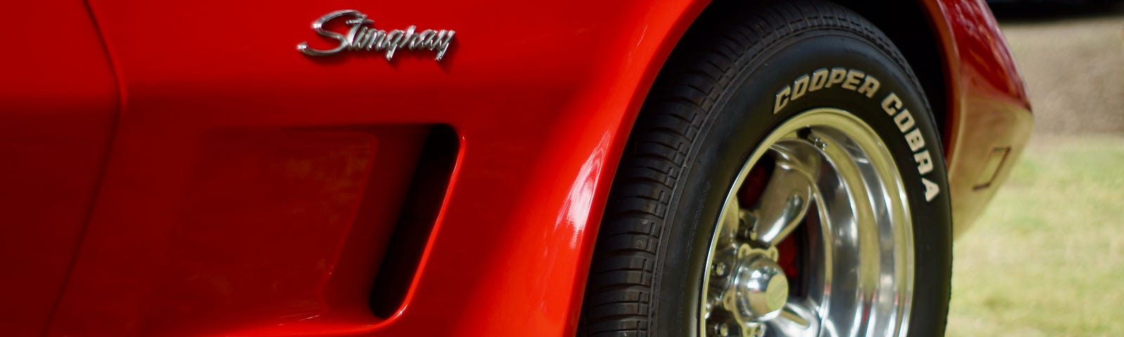 Front passenger side of a red corvette Stingray.