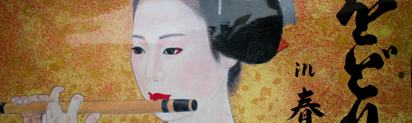 A painting of a geisha playing a flute. The background is a blend of yellow, gold fading into a green shade. There is caligraphy, Japanese writing on the right side of the picture. The geisha is dressed in a blue kimono robe. Her hair is pulled up in a bun and deocrated with red flowers.