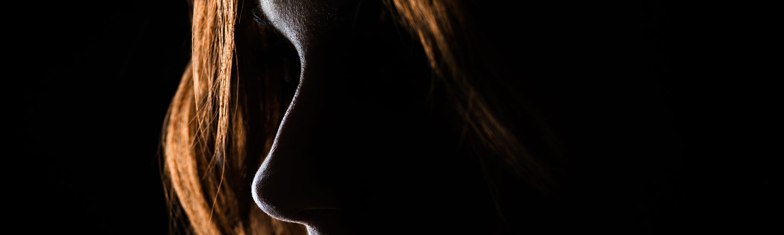 Redheaded girl in shadow.