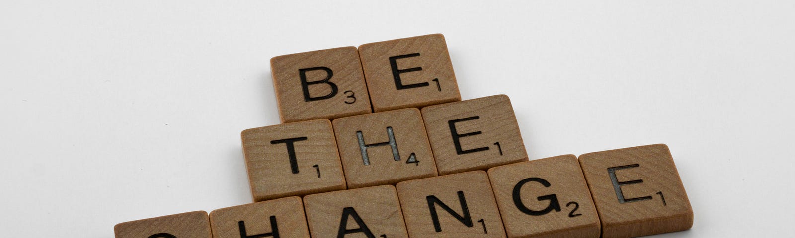 Scrabble tiles spell out “Be the Change.”