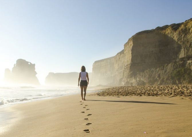 Woman walking away on a deserted beach.