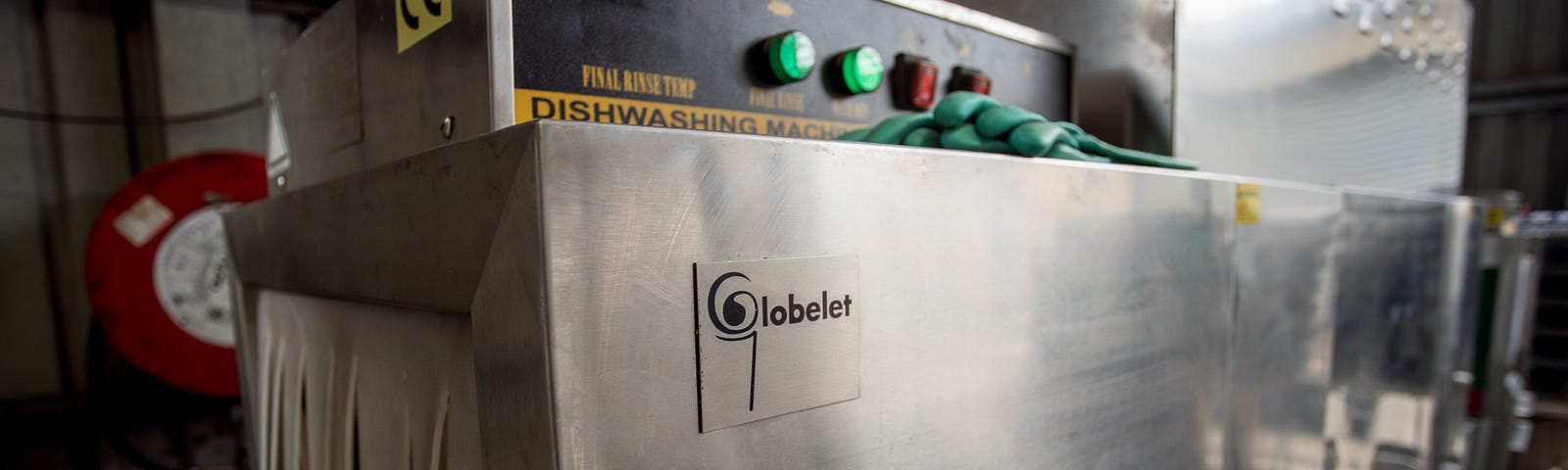 Close-up shot of a large stainless steel commercial dishwashing machine.