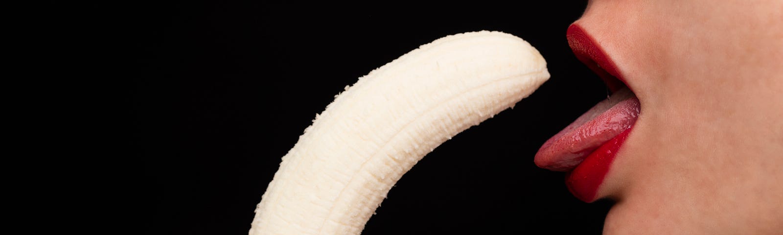 A very suggestive close-up snapshot of a woman about to swallow a freshly peeled banana!