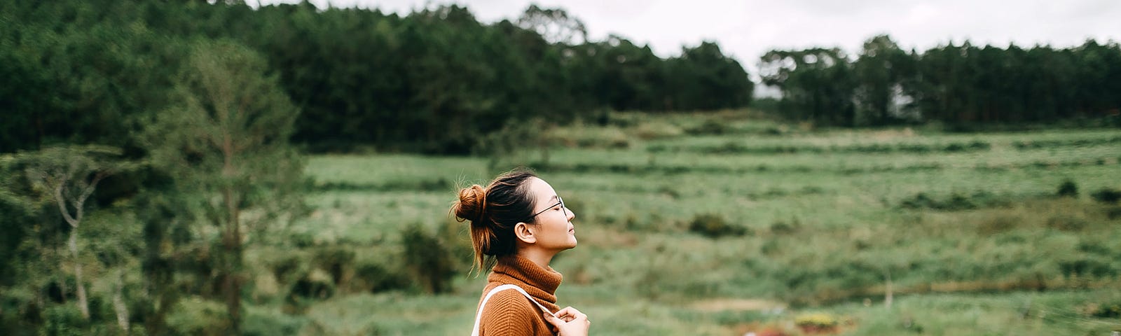 Woman in a field with a backpack