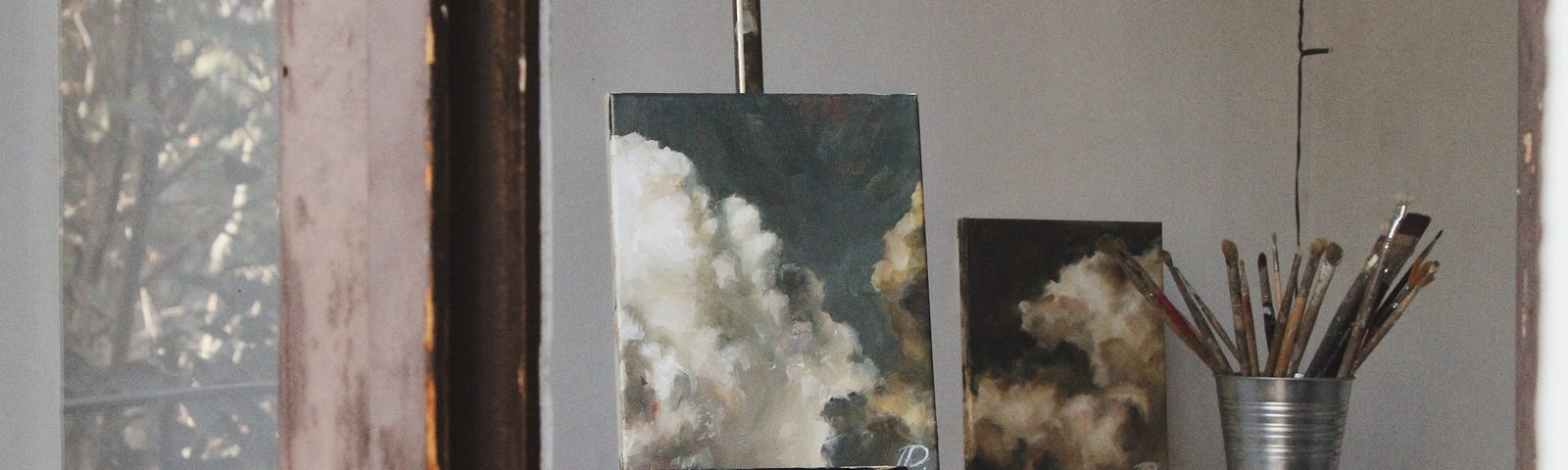 canvas with a painting of clouds in barren room