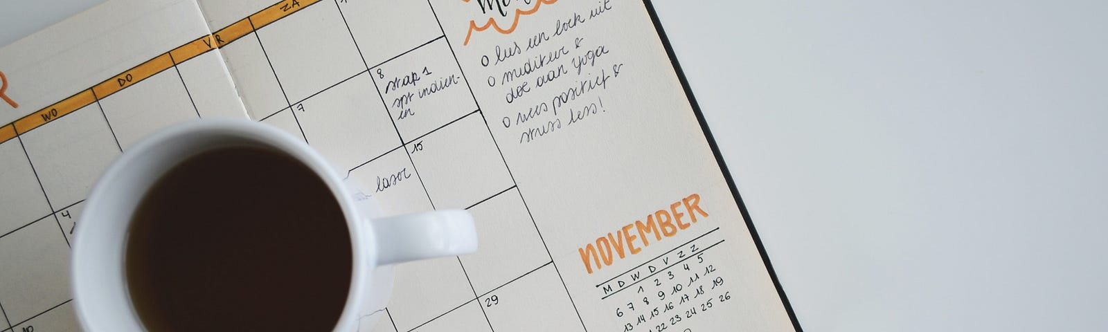 White ceramic coffee cup on an open calendar